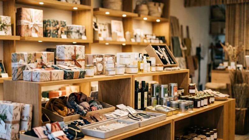 様々な予算帯の誕生日プレゼントが美しくディスプレイされたギフトショップの陳列棚